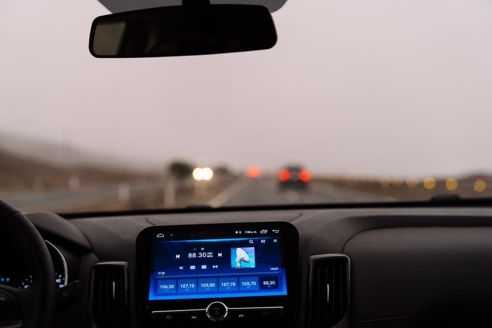 A car dashboard on an open road during the day