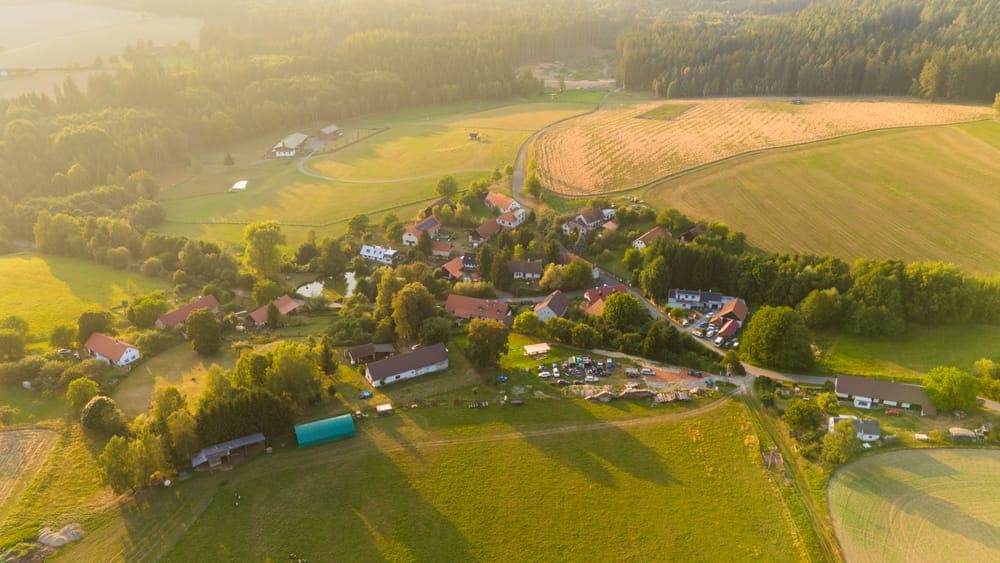 Aerial view of farm fields and forest around a small village