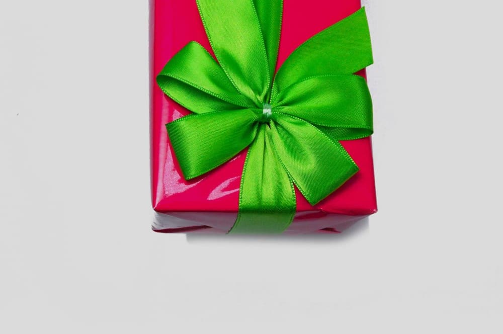 A red wrapped gift with a green ribbon bow