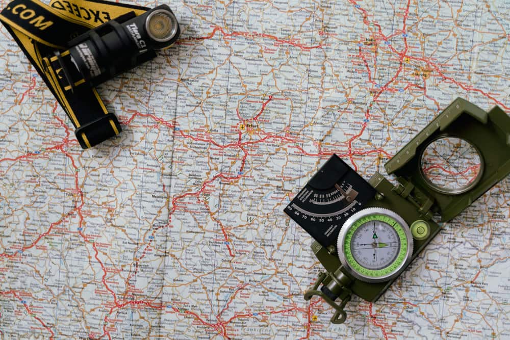 A paper map with a compass and a flashlight