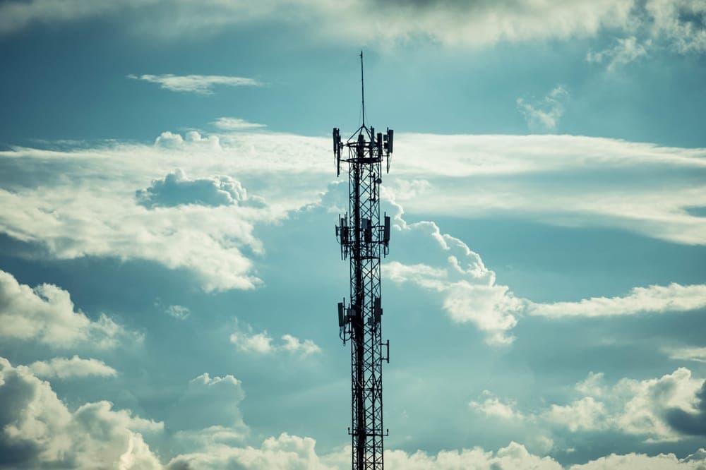 A communication tower against a dramatic cloudy sky