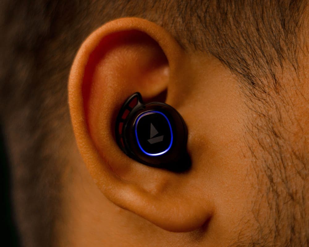 Close-up of a small earbud fitted in a person's ear