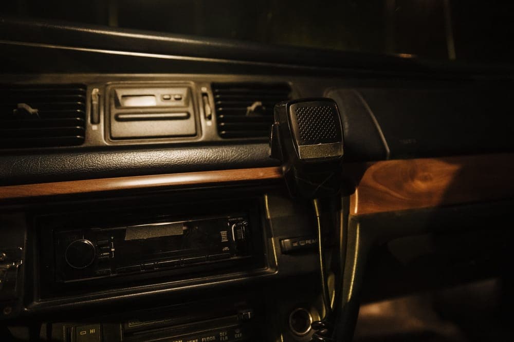 A vintage car dashboard with a radio and a handheld microphone